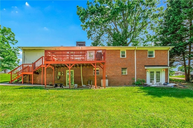 rear view of property featuring a deck, french doors, a yard, stairway, and brick siding