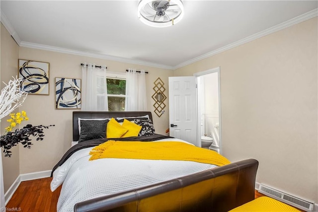 bedroom featuring wood finished floors, baseboards, crown molding, and connected bathroom