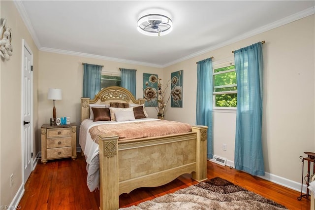 bedroom featuring dark wood finished floors, crown molding, and baseboards