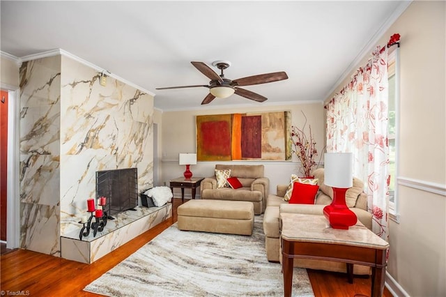 living room with wood finished floors, crown molding, and a ceiling fan