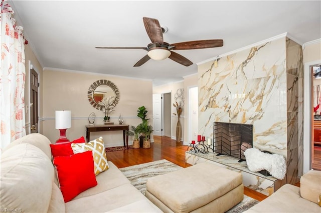 living area featuring crown molding, ceiling fan, and wood finished floors