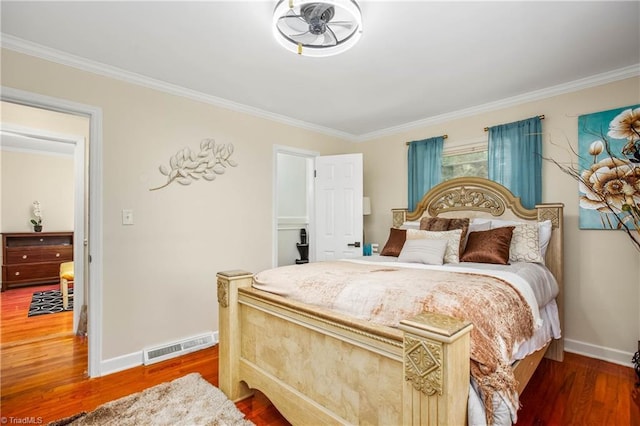 bedroom with crown molding, wood finished floors, and baseboards