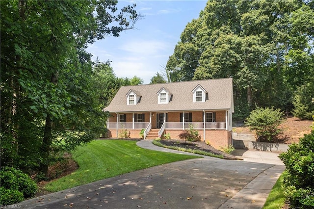 4028 Lofter Ct, Pfafftown, NC 27040 - cape cod-style house featuring covered porch, brick siding, a front lawn, and driveway