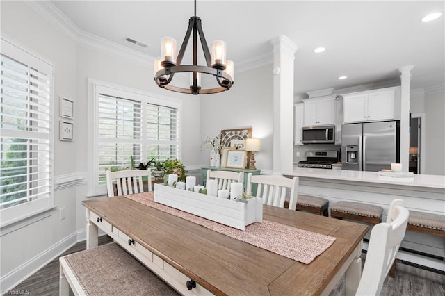 dining room with an inviting chandelier, ornamental molding, dark hardwood / wood-style flooring, and ornate columns