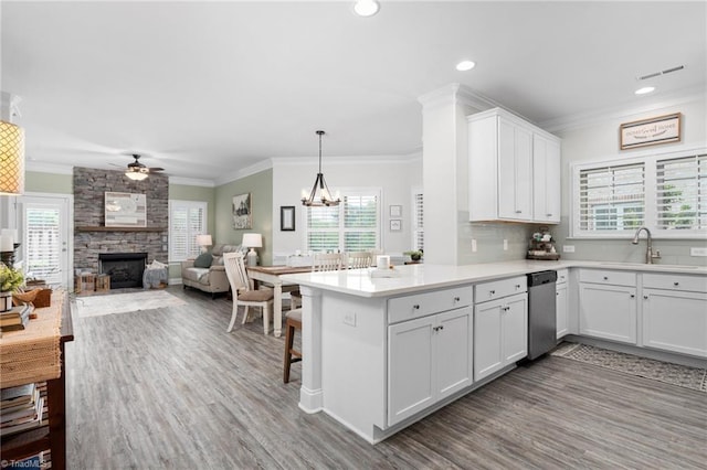 kitchen with pendant lighting, a breakfast bar, white cabinetry, ornamental molding, and kitchen peninsula