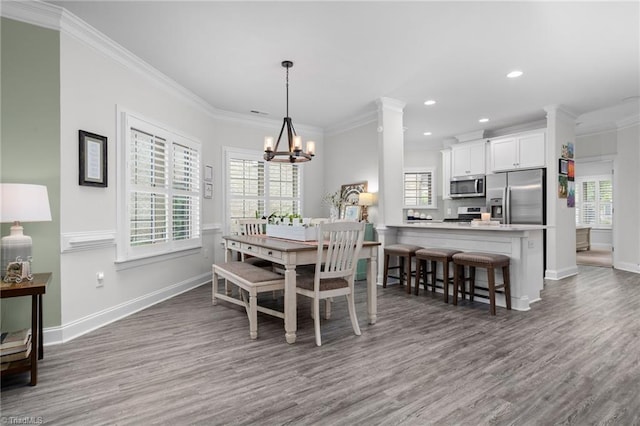 dining room featuring crown molding, hardwood / wood-style flooring, and a chandelier