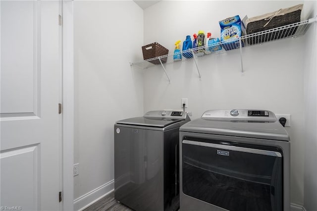 clothes washing area with hardwood / wood-style floors and independent washer and dryer