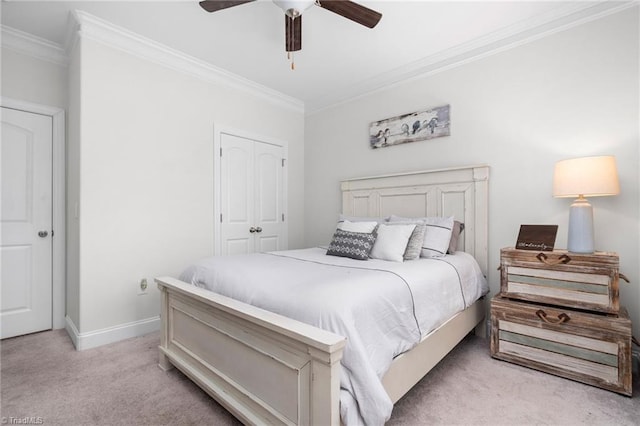 bedroom featuring ceiling fan, a closet, ornamental molding, and light carpet