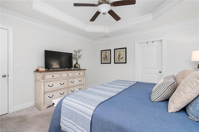 carpeted bedroom featuring ornamental molding and a tray ceiling