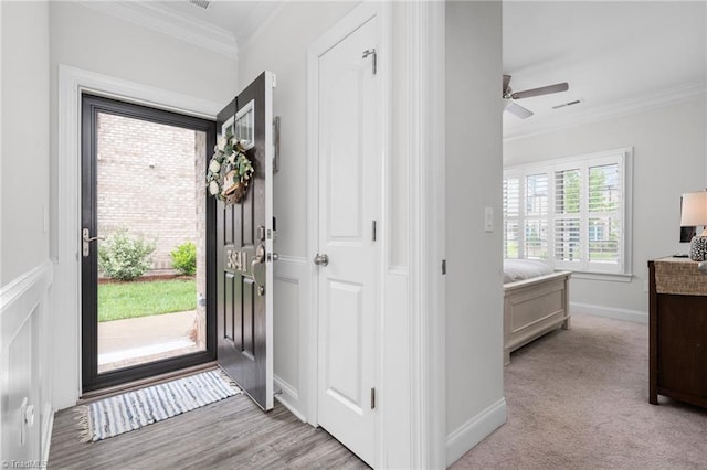 foyer featuring ornamental molding and ceiling fan