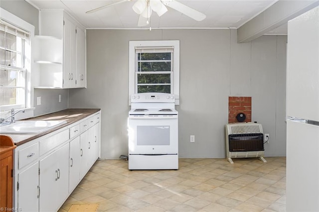 kitchen featuring white appliances, heating unit, ceiling fan, sink, and white cabinetry