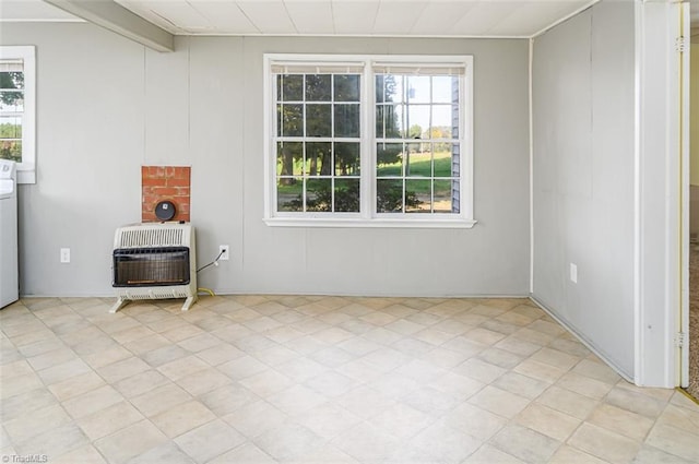 interior space featuring heating unit, beamed ceiling, and washer / dryer