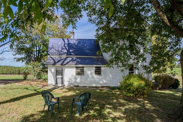 rear view of house featuring a yard