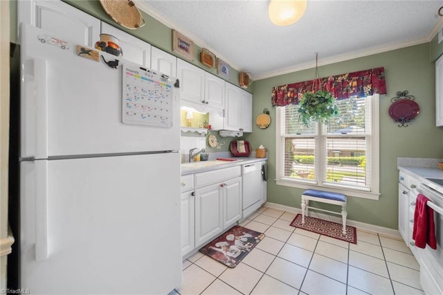 kitchen with white appliances, white cabinets, light countertops, a textured ceiling, and ornamental molding