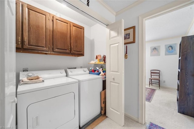 laundry room with cabinet space, crown molding, light carpet, and washing machine and clothes dryer