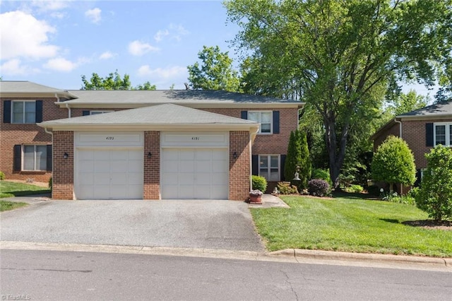 view of front facade with a garage, brick siding, driveway, and a front lawn