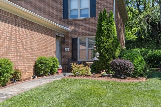 property entrance featuring brick siding and a yard