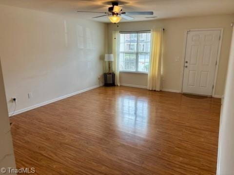 spare room featuring baseboards, a ceiling fan, and wood finished floors