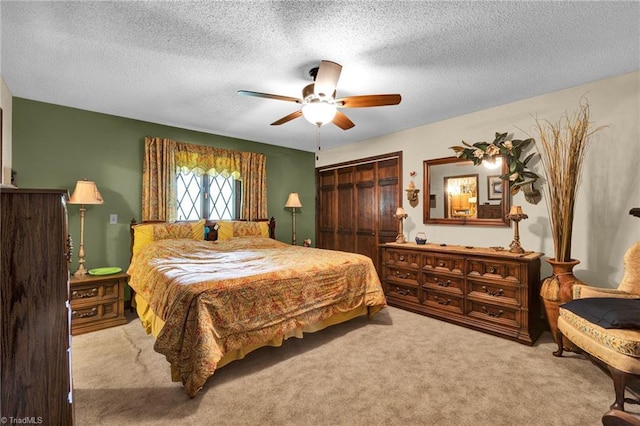 bedroom featuring light carpet, a closet, a textured ceiling, and ceiling fan