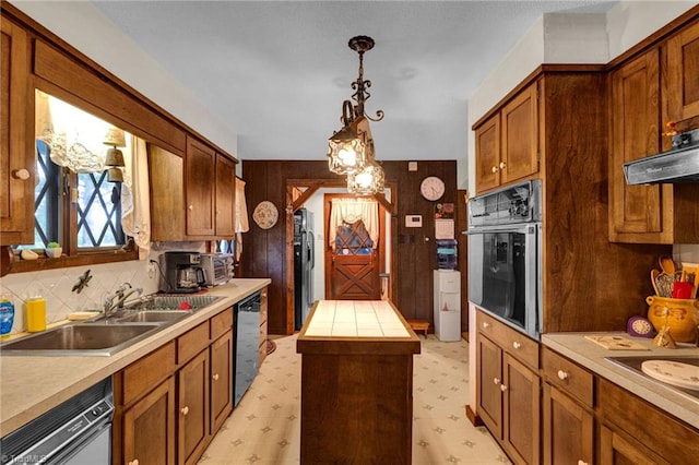 kitchen with oven, light tile patterned floors, pendant lighting, and backsplash