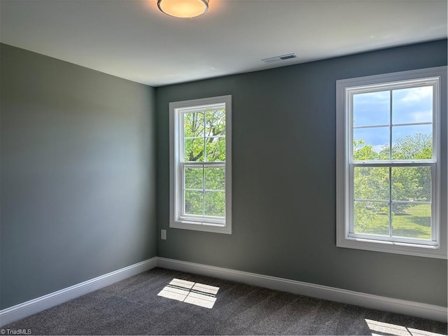 7376 Ridge Rd, Winston-Salem, NC 27107 - unfurnished room featuring baseboards, dark carpet, visible vents, and plenty of natural light