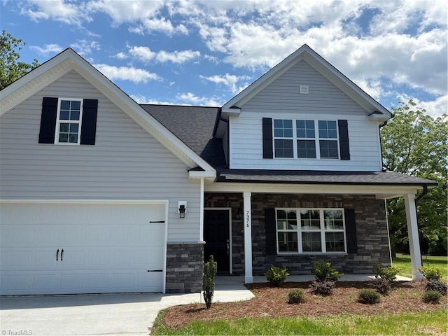 7376 Ridge Rd, Winston-Salem, NC 27107 - view of front facade with stone siding, a garage, concrete driveway, a porch, and roof with shingles