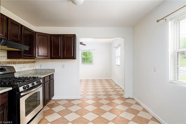 1309 Jackson St, Burlington, NC 27217 - kitchen featuring gas range, under cabinet range hood, backsplash, dark brown cabinets, and baseboards