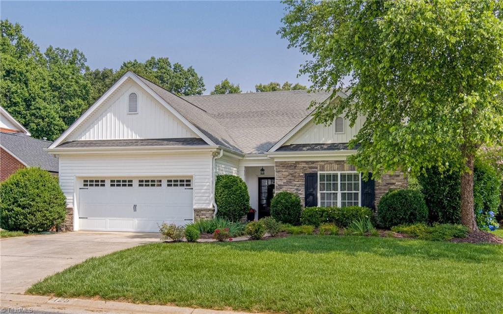 125 Valencia Ln, Winston-Salem, NC 27106 - craftsman-style home featuring board and batten siding, a garage, driveway, stone siding, and a front lawn