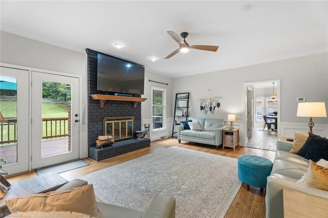 641 Doe Run Dr, Kernersville, NC 27284 - living area with ornamental molding, ceiling fan, wood finished floors, wainscoting, and a fireplace