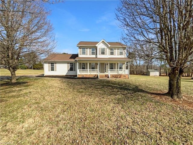 colonial house with covered porch, a storage shed, a front lawn, and an outdoor structure