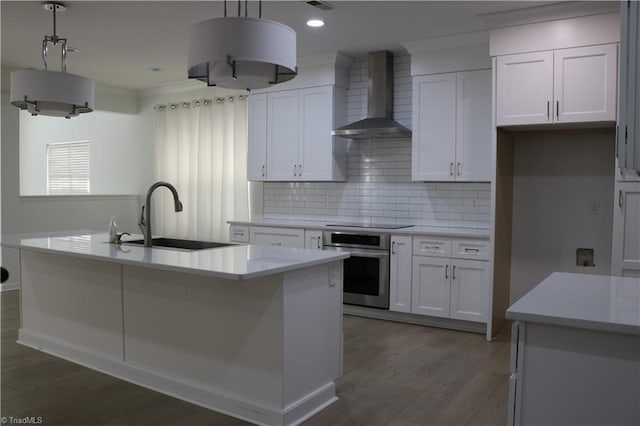 6215 Glen Way Dr, Winston-Salem, NC 27107 - kitchen featuring oven, wall chimney range hood, white cabinetry, light countertops, and wood finished floors