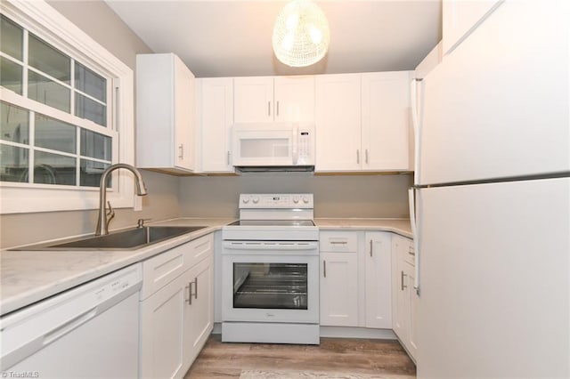 311 Salisbury St Unit 50, Kernersville, NC 27284 - kitchen featuring white appliances, a sink, light wood-type flooring, light countertops, and white cabinets
