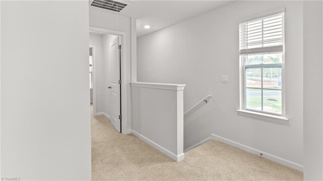 hallway featuring light colored carpet