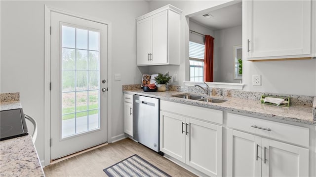 kitchen with sink, light hardwood / wood-style flooring, light stone countertops, white cabinets, and stainless steel dishwasher