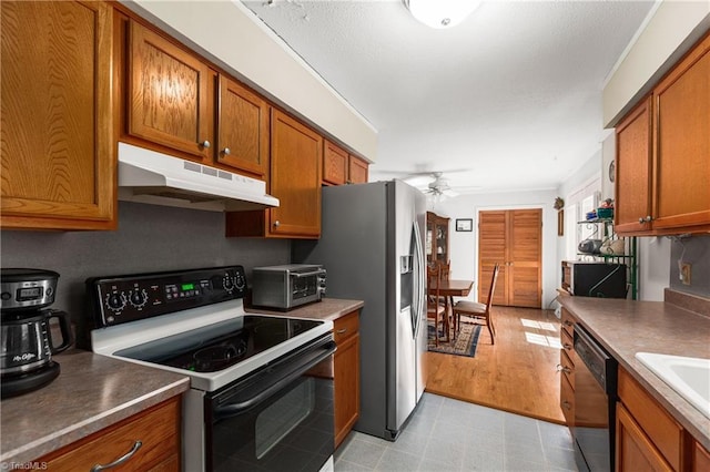 213 Timmys Ln, King, NC 27021 - kitchen with electric stove, under cabinet range hood, black dishwasher, a ceiling fan, and brown cabinetry