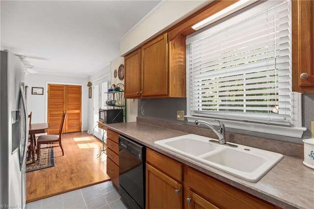213 Timmys Ln, King, NC 27021 - kitchen with stainless steel fridge with ice dispenser, black dishwasher, brown cabinets, a ceiling fan, and light tile patterned floors