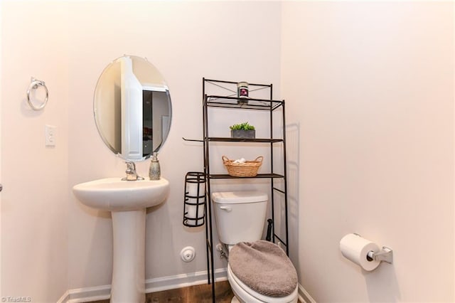 bathroom with hardwood / wood-style floors, toilet, and sink