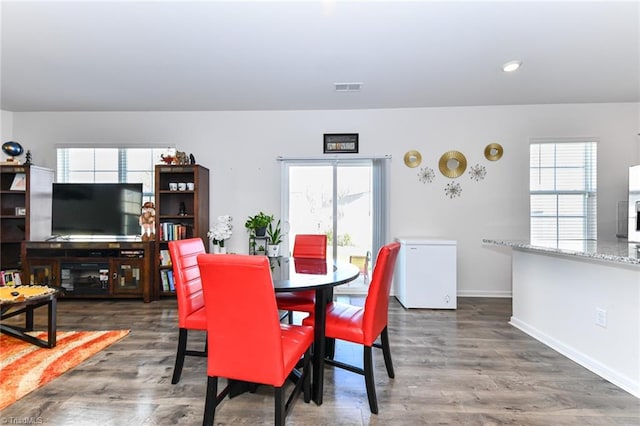 dining space with dark hardwood / wood-style floors