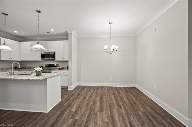 kitchen with a sink, ornamental molding, appliances with stainless steel finishes, and baseboards