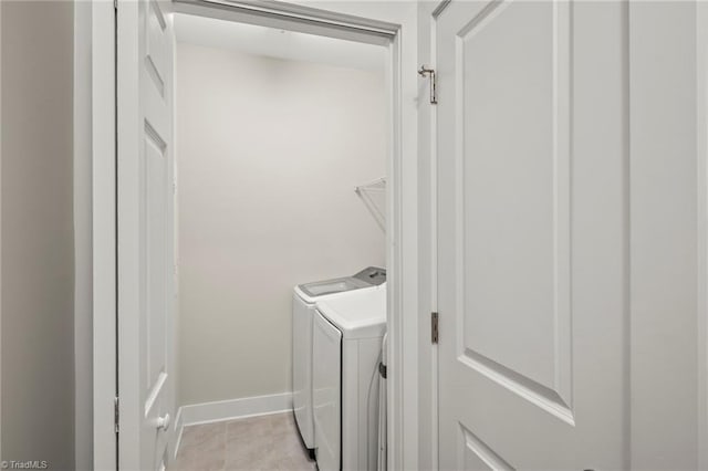 laundry room featuring washing machine and clothes dryer, baseboards, laundry area, and light tile patterned floors