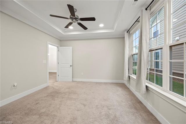 carpeted spare room with a tray ceiling, recessed lighting, baseboards, visible vents, and a ceiling fan