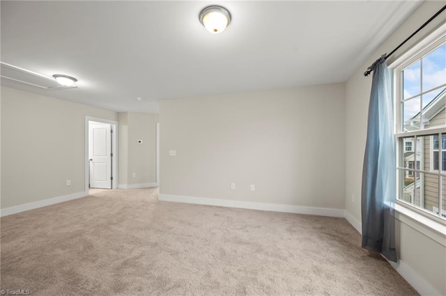 spare room featuring baseboards and light colored carpet