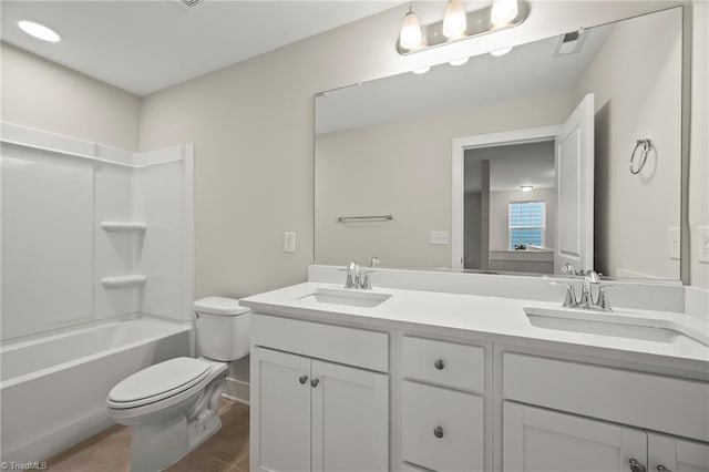 full bath featuring toilet, a sink, double vanity, and visible vents