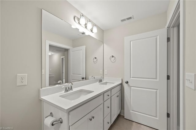 bathroom with double vanity, a sink, tile patterned floors, and visible vents