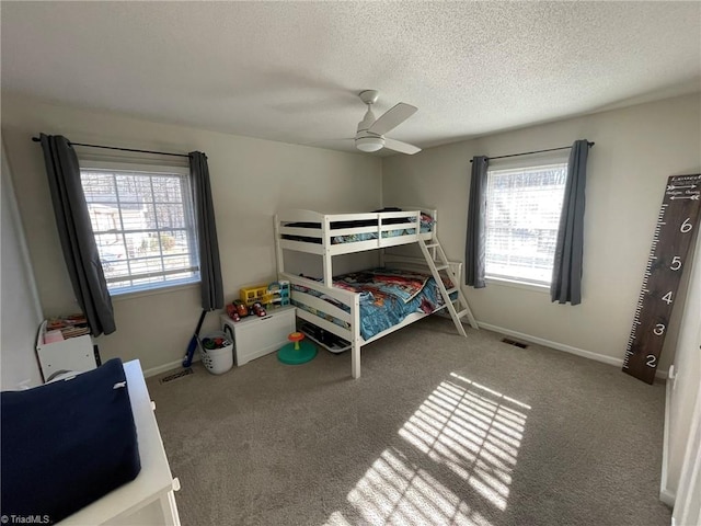 carpeted bedroom featuring a textured ceiling and ceiling fan