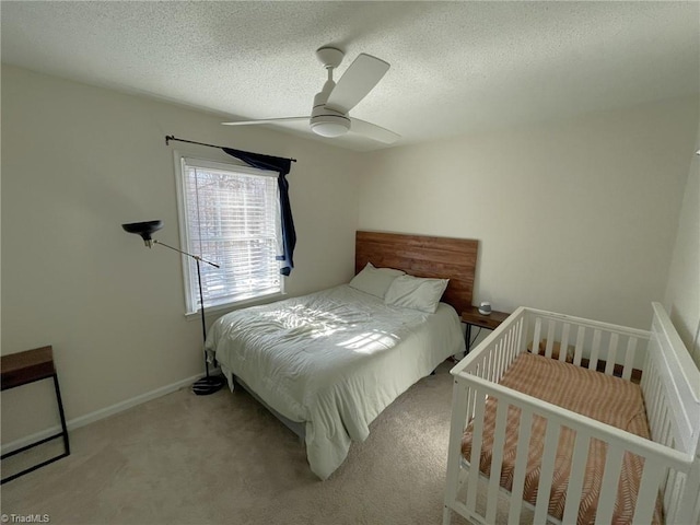 carpeted bedroom with a textured ceiling and ceiling fan