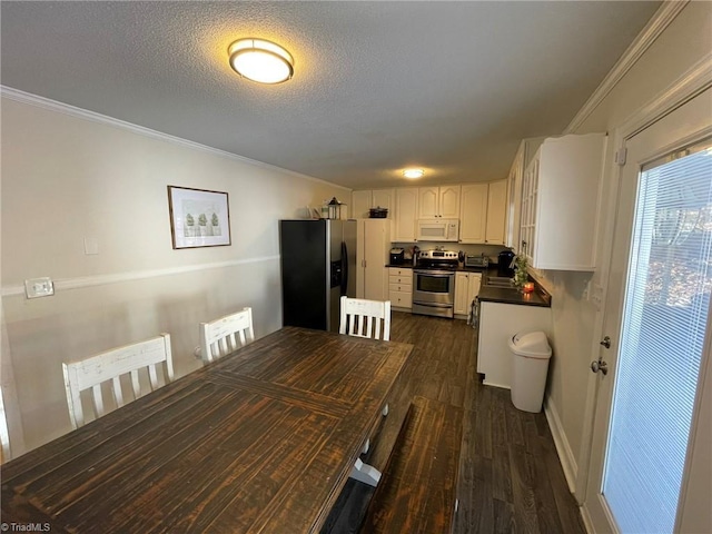 dining room with a textured ceiling, dark hardwood / wood-style floors, and ornamental molding