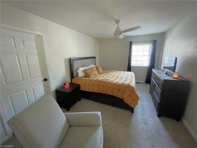 bedroom with ceiling fan and light carpet