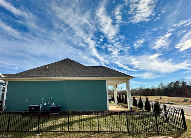 view of side of property featuring central AC unit and fence