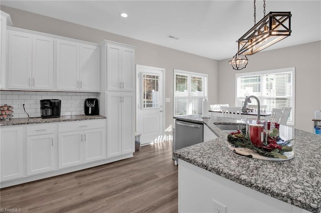 kitchen featuring sink, white cabinets, stainless steel dishwasher, and light wood-type flooring